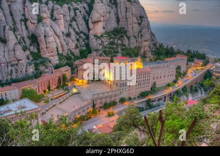 Panoramablick bei Sonnenuntergang auf die Abtei Santa Maria de Montserrat in Spanien. Stockfoto