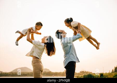 Eine glückliche Familie genießt verspielte Momente auf einem Sommerfeld Stockfoto