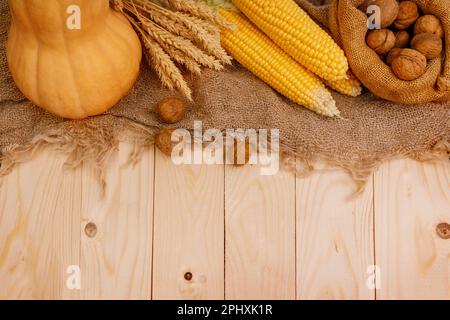 Holztisch mit Kürbissen, Mais und Herbstdekor Stockfoto