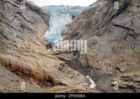 Eiswasserfall in einem Gletscher in Norwegen mit den Rocky Mountains und einem See aus geschmolzenem Eis Stockfoto