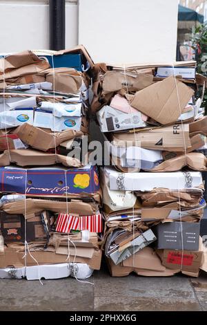 Zwei Stapel flacher Pappkartons, die in einer Straße in Soho, London, gestapelt und zum Recycling abgeholt werden müssen. Anna Watson/Alamy Stockfoto