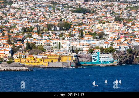 Die senffarbene, gelb bemalte Festung Sao Tiago der Hauptstadt Funchal, Madeira, Portugal, vom Meer aus gesehen. Stockfoto