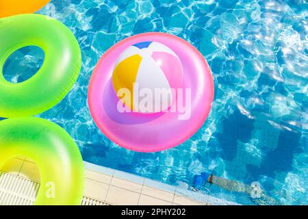 Aufblasbarer Poolball auf Rettungsring im Pool Stockfoto