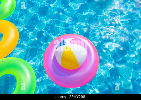 Aufblasbarer Poolball auf Rettungsring im Pool Stockfoto