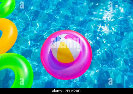 Aufblasbarer Poolball auf Rettungsring im Pool Stockfoto