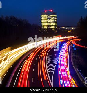 Helle Autosträhne auf der Autobahn A52 ein EON-Hauptsitz am Abend, Deutschland, Nordrhein-Westfalen, Ruhrgebiet, Essen Stockfoto