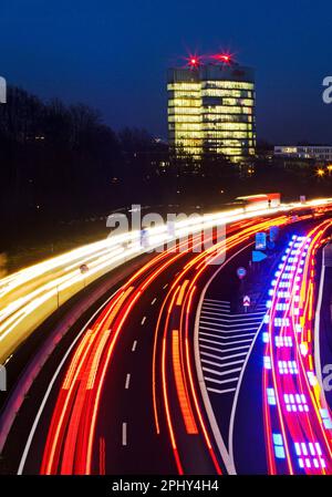 Helle Autosträhne auf der Autobahn A52 ein EON-Hauptsitz am Abend, Deutschland, Nordrhein-Westfalen, Ruhrgebiet, Essen Stockfoto