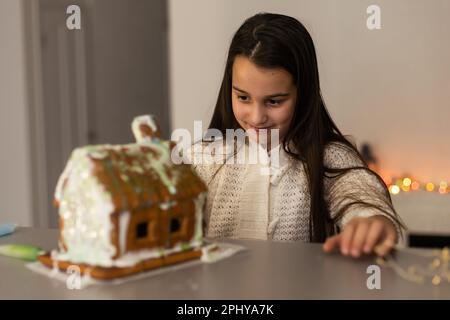 Ein junges Mädchen, das zu Hause Lebkekse macht. Stockfoto