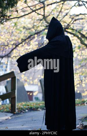 Ein vertikales Bild einer Skelettfigur in einem langen, dunklen Gewand und Kapuze Stockfoto