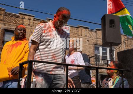 Eine Gruppe von Menschen, die bei der Phagwah Holi Parade 2023 in Queens, NY, Farbpulver auf sich verteilen Stockfoto