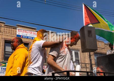 Eine Gruppe von Menschen, die bei der Phagwah Holi Parade 2023 in Queens, NY, Farbpulver auf sich verteilen Stockfoto