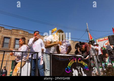 Eine Gruppe von Menschen, die bei der Phagwah Holi Parade 2023 in Queens, NY, Farbpulver auf sich verteilen Stockfoto