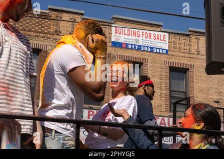 Eine Gruppe von Menschen, die bei der Phagwah Holi Parade 2023 in Queens, NY, Farbpulver auf sich verteilen Stockfoto