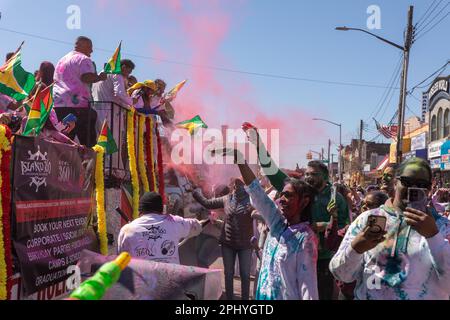 Eine Gruppe von Menschen, die bei der Phagwah Holi Parade 2023 in Queens, NY, Farbpulver auf sich verteilen Stockfoto