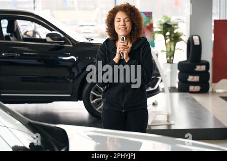 Glücklicher Kunde, der einen Autoschlüssel in der Hand hält Stockfoto