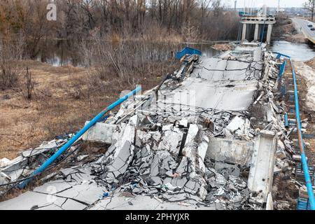 Die zerstörte Brücke über den Fluss in der Nähe von Izyum, Charkiv Region. Izyum in der ukrainischen Charkiv-Region, sechs Monate nach dem Rückzug der russischen Armee. Obwohl die Stadt nicht mehr unter Beschuss steht, besteht aufgrund von Minen, Stolperdrähten und nicht explodierten Kampfmitteln immer noch ein hohes Explosionsrisiko. Izyum wurde am 10. September 2022 während einer Gegenoffensive der ukrainischen Streitkräfte befreit, aber die Stadt wurde durch russische Bomben und Besetzung schwer beschädigt, wobei 80 % der Gebäude beschädigt wurden. Massengräber von ukrainischen Zivilisten und Soldaten, einschließlich Anzeichen von Folter, waren ebenfalls Disketten Stockfoto