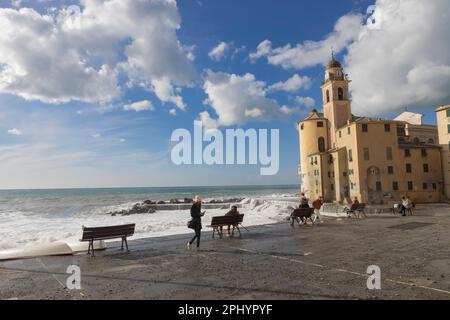 CAMOGLI, ITALIEN, 18. JANUAR 2023 - raues Meer am Pier von Camogli und die Basilika Santa Maria Assunta, Provinz Genua, Italien. Stockfoto