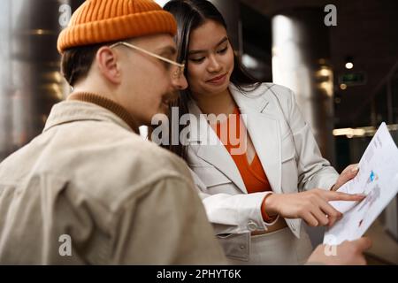 Zwei junge Mitarbeiter des Unternehmens, die geschäftliche Angelegenheiten besprechen Stockfoto