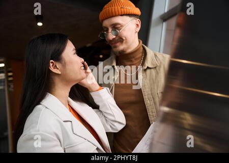Fröhliche Geschäftsfrau, die mit ihrem Begleiter telefoniert Stockfoto