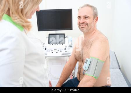 Arzt, der den holter-Monitor zur täglichen Überwachung eines Elektrokardiogramms anwendet Stockfoto