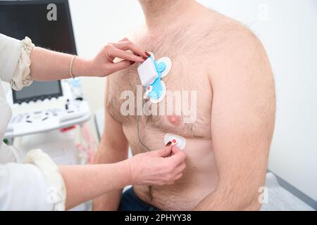 Männlicher Patient mit Sensoren am Körper zur Überwachung von Arrhythmien Stockfoto