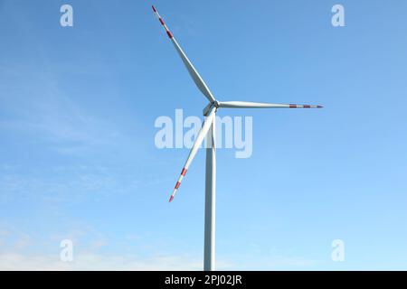 Moderne Windturbine vor blauem Himmel. Alternative Energiequelle Stockfoto