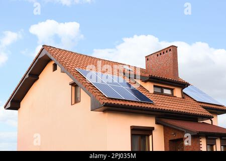 Haus mit installierten Sonnenkollektoren auf dem Dach. Alternative Energie Stockfoto