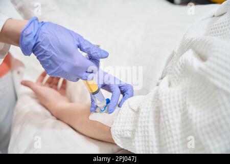 Anästhesist, der intravenöse Infusionen für unerkannte Patienten im Krankenhaus durchführt Stockfoto