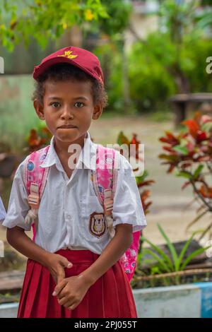 Waisai, West Papua, Indonesien - Februar 2023: Porträt eines Schuljungen in rot-weißer Uniform, der auf den Raja Ampat-Inseln auf der Straße spaziert Stockfoto