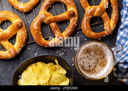 Frisch gebackene hausgemachte Brezeln und Bier vom Fass. Flach liegend Stockfoto