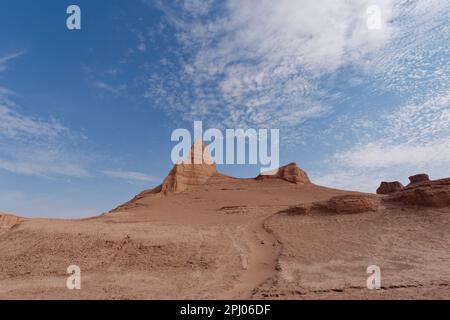 Eine atemberaubende Wüstenlandschaft mit hohen, roten Felsformationen vor einem hellblauen Himmel Stockfoto