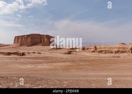 Eine atemberaubende Wüstenlandschaft mit hohen, roten Felsformationen vor einem hellblauen Himmel Stockfoto