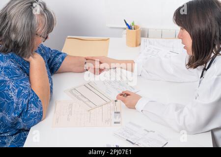 Junge Ärztin, die ihrem Patienten ein Rezept übergibt Stockfoto
