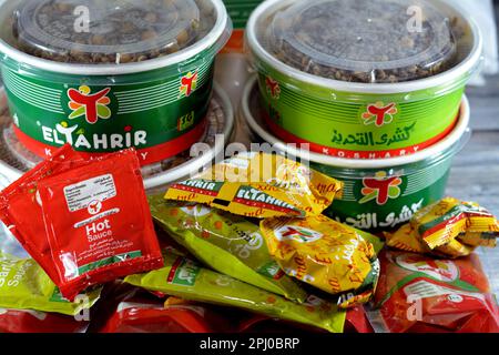 Kairo, Ägypten, März 28 2023: El Tahrir Koshary Koshari, Street Food aus Reis, Makkaroni, Spaghetti und Linsen, garniert mit würziger Tomatensoße, Stockfoto