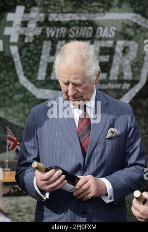 Finowfurt, Deutschland. 30. März 2023. Der britische König Karl III. (L) sieht sich bei seinem Besuch im 130. Englisch-deutschen Brückenbrücke-Bataillon in Finowfurt eine Flasche Wein an. Vor seiner Krönung im Mai 2023 werden der britische König und die königliche Ehefrau Deutschland für drei Tage besuchen. Kredit: Jens Schlueter/POOL/AFP/dpa/Alamy Live News Stockfoto