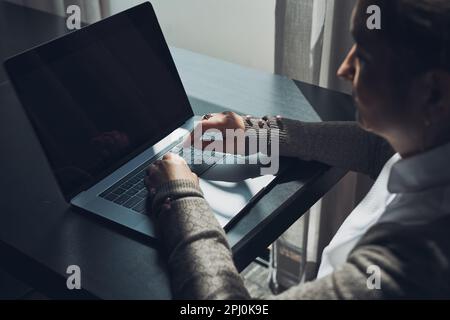 Fokussierte Geschäftsfrau, die Remote auf ihrem Laptop arbeitet, erwägt die Verwaltung Ihre Arbeit sitzt am Tisch in einem Café Stockfoto