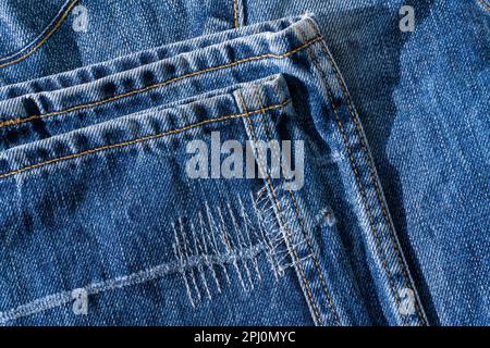 Details der blauen Jeans – Saum mit dekorativen Nähten im Hintergrund Stockfoto