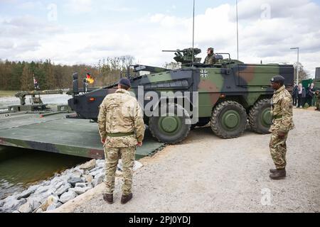 Finowfurt, Deutschland. 30. März 2023. Während des Besuchs des englischen Königs beim englisch-deutschen Brückenbrückenbataillon 130. in Finowfurt fährt ein Multirolle-Panzerfahrzeug (MRAV) der Deutschen Armee in Richtung M3 Amphibienfahrzeuge, die eine Brücke unter ihnen auf dem Wasser bilden. Vor seiner Krönung im Mai 2023 werden der britische König und königliche Gemahlin Deutschland für drei Tage besuchen. Kredit: Jens Schlueter/AFP Pool/dpa/Alamy Live News Stockfoto