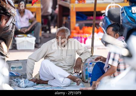 Haridwar, Indien - Okt. 2022: Straßenfriseur wartet mit Rasier- und Haarschneideausrüstung in der Nähe des ganges in haridwar auf den Kunden. Stockfoto