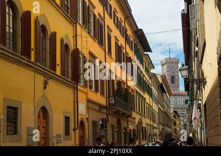 Die Via di Ricasoli in Florenz, Italien, führt an der Galleria dell'Accademia vorbei, in der sich Michelangelos David befindet und hinter dem Glockenturm der Kathedrale. Stockfoto