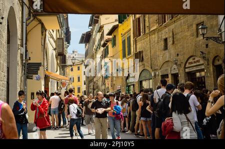 Eine lange Schlange von Besuchern zur Mittagszeit steht für Panini von einem beliebten Händler in einer engen Straße in Florenz, Italien. Stockfoto