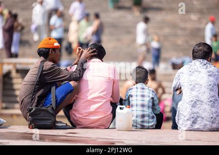 Haridwar, Indien - Okt. 2022: Straßenfriseur wartet mit Rasier- und Haarschneideausrüstung in der Nähe des ganges in haridwar auf den Kunden. Stockfoto