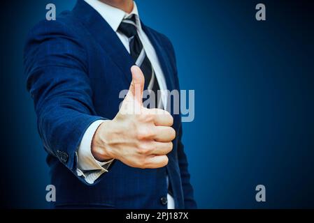 Ein Geschäftsmann zeigt eine "Daumen hoch" -Geste. Nonverbale Kommunikation Stockfoto