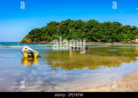 Atemberaubender Withe-Strand in bertioga im Bundesstaat Sao Paulo mit Regenwald, Meer und im Sand verankerten Schnellbooten Stockfoto