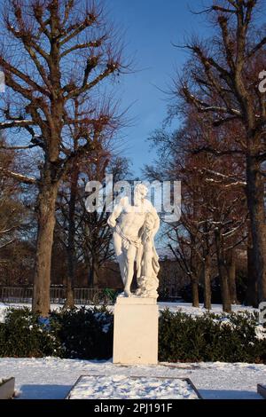 Karlsruhe, Deutschland - 12. Februar 2021: Statue vor Bäumen an einem sonnigen Winternachmittag im Karlsruher-Palast in Deutschland. Stockfoto