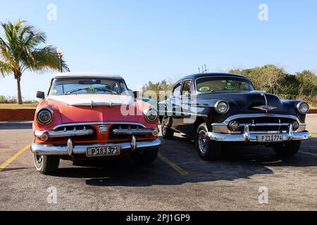 Oldtimer-Autos Dodge und Chevrolet parken auf einer Straße mit Palmen im Hintergrund, Touristentaxi Stockfoto