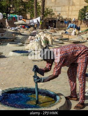 Ein Mann arbeitet in einer lokalen Textilindustrie in Kano. Kofar Mata Färbegruben ist eine lokale Textilindustrie in Kano, gegründet 1498 und die älteste im Bundesstaat Kano. Es soll etwa 250 Farbgruben haben, die zum Färben von Baumwollmaterialien und zur Herstellung verschiedener Designs auf Kleidung verwendet werden. Nigeria. Stockfoto