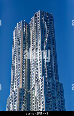 8 Spruce Street, auch bekannt als New York by Gehry, hat eine gewellte Wandfassade aus Edelstahl, die angeblich einen echten Vorhang imitiert. Stockfoto