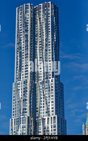 8 Spruce Street, auch bekannt als New York by Gehry, hat eine gewellte Wandfassade aus Edelstahl, die angeblich einen echten Vorhang imitiert. Stockfoto