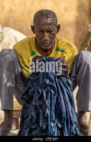 Ein Mann arbeitet in einer lokalen Textilindustrie in Kano. Kofar Mata Färbegruben ist eine lokale Textilindustrie in Kano, gegründet 1498 und die älteste im Bundesstaat Kano. Es soll etwa 250 Farbgruben haben, die zum Färben von Baumwollmaterialien und zur Herstellung verschiedener Designs auf Kleidung verwendet werden. Nigeria. Stockfoto